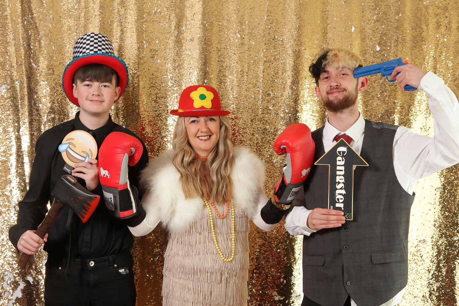 People enjoying a photo booth with costumes and props at an event.