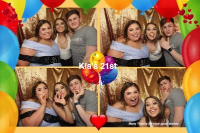 Group of friends celebrating Kia's 21st birthday in a photo booth.