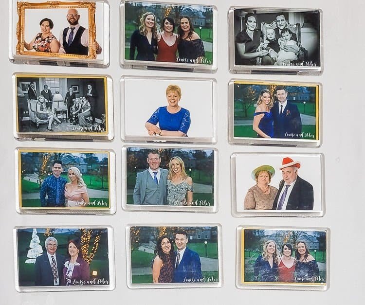 A collection of 13 rectangular photo magnets arranged on a white surface, each featuring different people posing in pairs or groups, some smiling, with a mix of colour and black-and-white images.